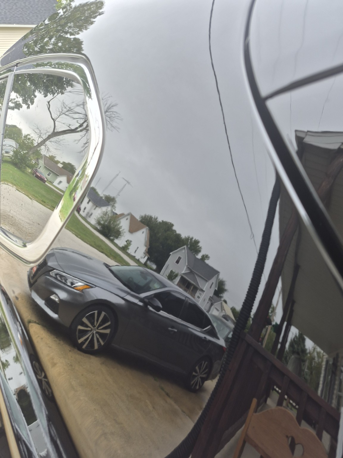 Gray Nissan reflected in glossy freshly waxed paint